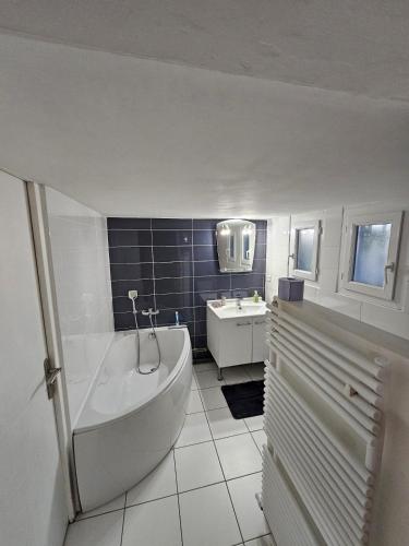 une salle de bain blanche avec une baignoire et un lavabo dans l'établissement Superbe maison avec piscine en centre ville, à Narbonne