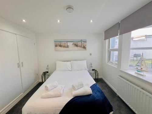 Un dormitorio blanco con una cama grande con dos almohadas. en The Barbican Penthouse, en Plymouth