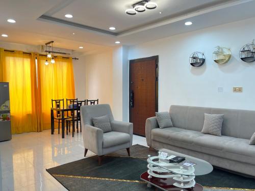 a living room with a couch and chairs and a table at Kassardjian Apartments in Accra