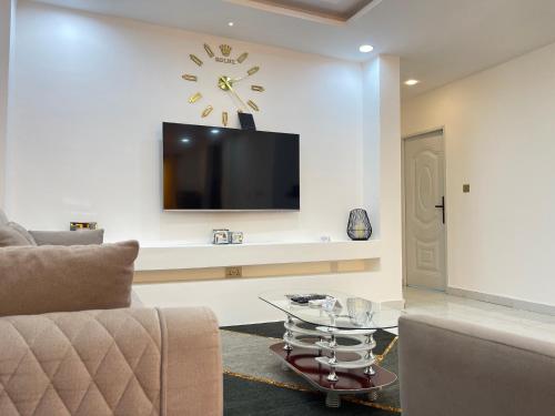 a living room with a couch and a clock on the wall at Kassardjian Apartments in Accra