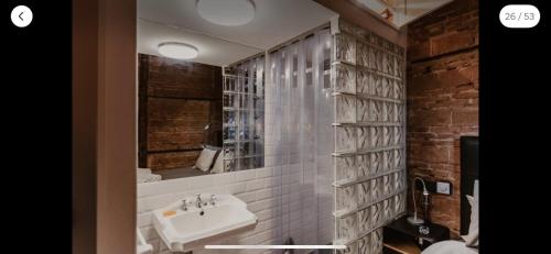 ein Badezimmer mit Waschbecken und Spiegel in der Unterkunft El antiguo taller de Guantes in Madrid