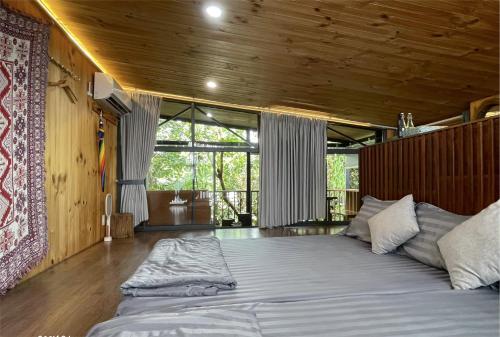 a large bed in a room with a wooden ceiling at TROPICAL GARDEN Homestay in Buôn Alê (1)