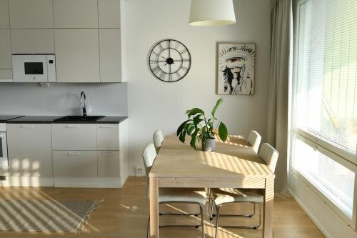 a kitchen and dining room with a table and a clock at Seaside Escape Oulu in Oulu