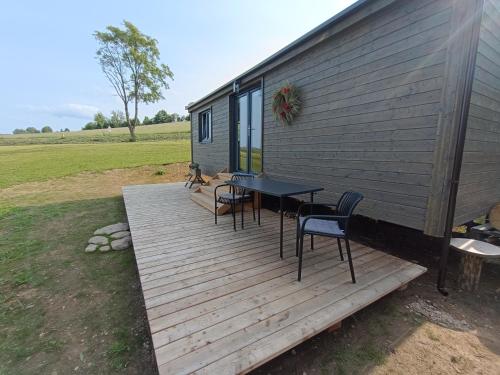 a deck with a table and chairs next to a building at Maringotka U Skalek in Hlavňovice