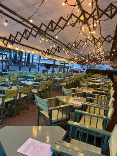 un restaurant avec de nombreuses tables, chaises et lumières dans l'établissement Panter Properies Studio, à Cannes