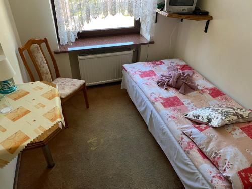 a small room with a bed and a table and chair at Titanic in Władysławowo