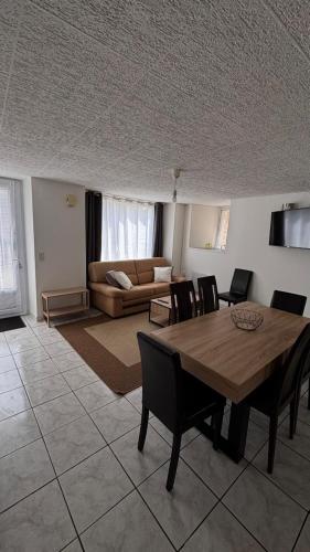 un salon avec une table, des chaises et un canapé dans l'établissement Petite maison de bourg, à Broons