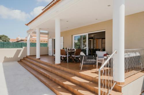 a home with a large deck with a dining table at Villa Victoria Paradise in Cala en Blanes