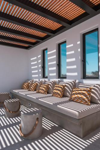 a large couch in a room with windows at Noir Mykonos in Mýkonos City