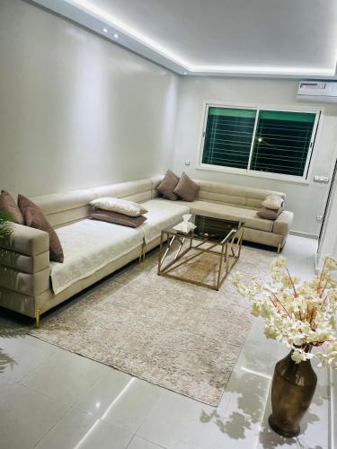a living room with a couch and a table at The hidden oasis, steps from the beach and pool in Mohammedia
