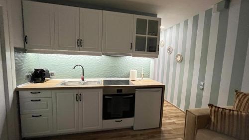 a kitchen with white cabinets and a sink at Central Haven in Volos