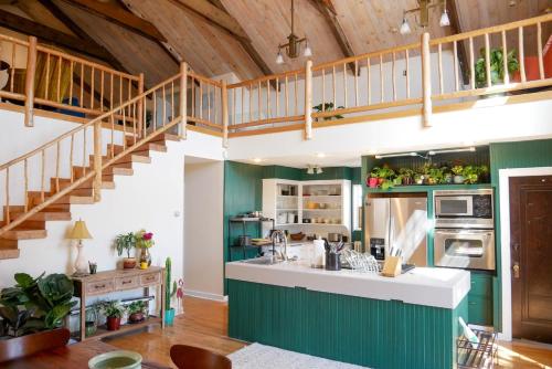 a kitchen with green walls and a wooden ceiling at Mountain Jungalow Chalet, 3 min walk to Royal Gorge Train in Canon City