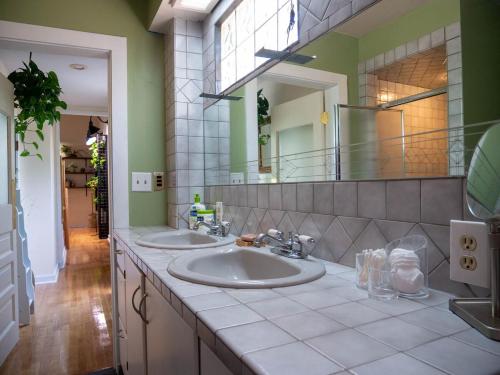 a bathroom with two sinks and a large mirror at Mountain Jungalow Chalet, 3 min walk to Royal Gorge Train in Canon City