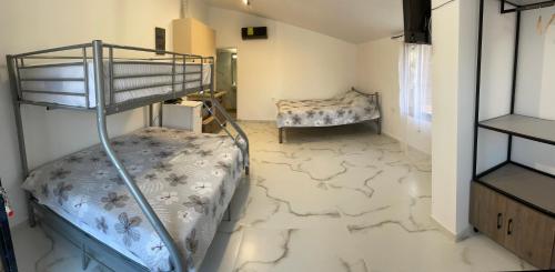 a room with a bunk bed and a bedroom with marble floors at AlMa Studios in Asprovalta