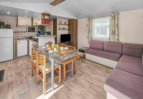 une cuisine et un salon avec une table et un canapé dans l'établissement Cerisya, terrasse semi couverte, à Litteau