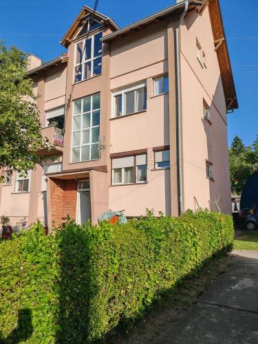 a pink building with bushes in front of it at Mountain LUX in Rudnik Kačerski