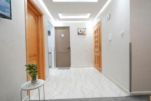 a hallway with a door and a table and a stool at Résidence America in Dakhla