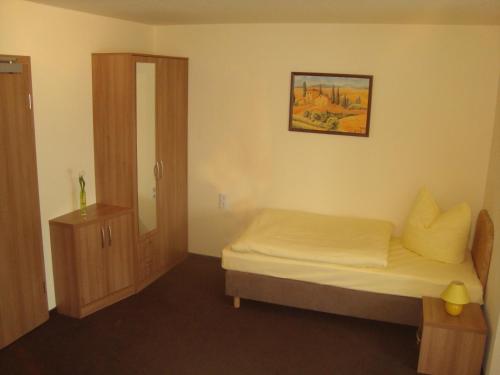 a small bedroom with a bed and a cabinet at Hotel Gasthof Goldener Hahn in Frankfurt/Oder