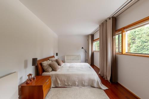 a bedroom with a bed and a large window at 125 House - Swimming Pool, Tennis, Golf & Nature in Esposende