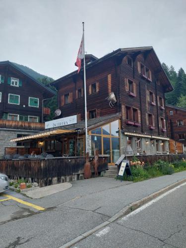 BlitzingenにあるGasthaus Tschiffraの旗が目の前に掲げられた大きな木造建築
