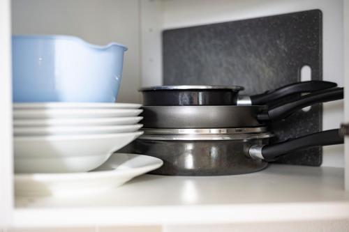 a stack of bowls and plates on a kitchen counter at Flat at border suisse in Saint-Louis
