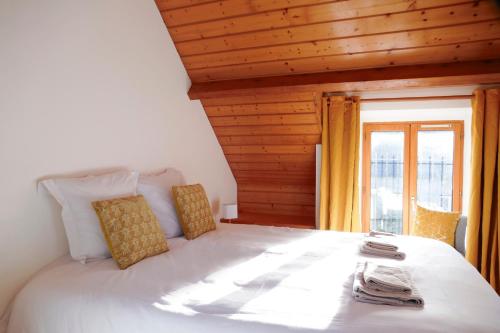 une chambre avec un grand lit blanc avec une fenêtre dans l'établissement Le clos des Ty, à La Baule