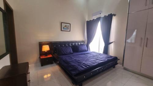 a black bed in a room with a window at Haven Lodge, Cliffside Residences in Bhurban