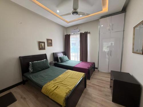 a bedroom with two beds and a ceiling at Haven Lodge, Cliffside Residences in Bhurban