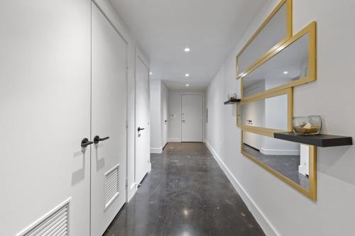a hallway with white walls and a mirror on the wall at Luxury Loft-Coastal Vibe in Dallas