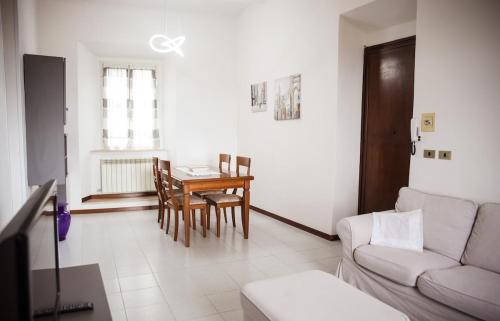a living room with a couch and a dining room table at La Casa in Piazza - Super terrazza - 18' dalle Terme in Manciano