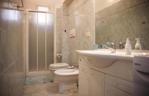 a bathroom with a toilet and a sink and a shower at La Casa in Piazza - Super terrazza - 18' dalle Terme in Manciano