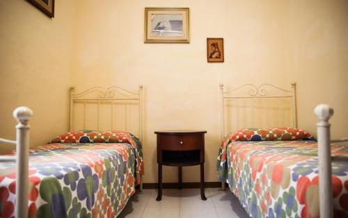 a bedroom with two beds and a table in it at La Casa in Piazza - Super terrazza - 18' dalle Terme in Manciano
