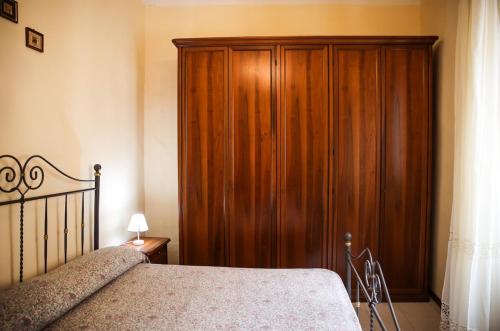 a bedroom with a wooden cabinet next to a bed at La Casa in Piazza - Super terrazza - 18' dalle Terme in Manciano