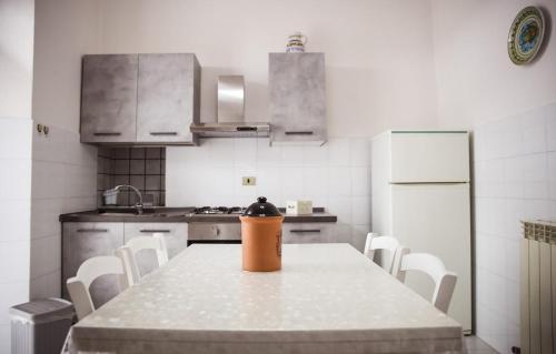 a kitchen with a table with a trash can on it at La Casa in Piazza - Super terrazza - 18' dalle Terme in Manciano
