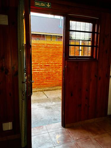 an open door to a room with a brick wall at La martina in Junín de los Andes
