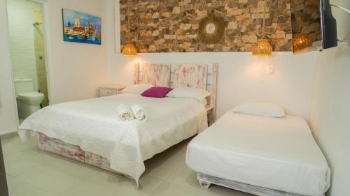 a bedroom with two beds with towels on them at Casa Playa James in La Boquilla