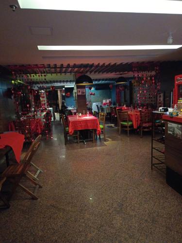 a dining room with red tables and chairs in a restaurant at PEDRA BONITA PRECIOSO HOTEL ltda in Itaboraí