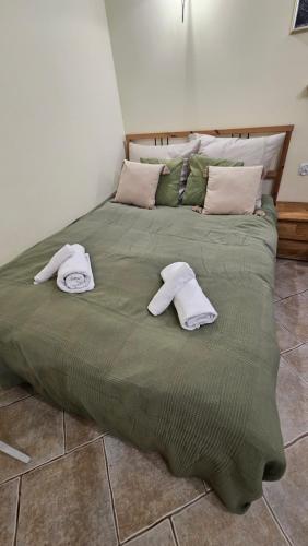a large green bed with two towels on it at Baltic Swans - Studio in Sopot