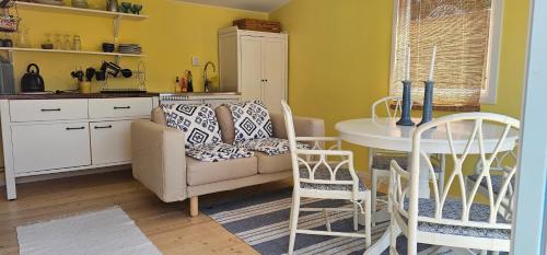 a kitchen with a couch and a table and chairs at Ocean Breeze next to the Beach in Beddinge Strand