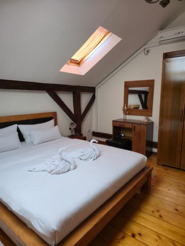 a bedroom with a large white bed with a skylight at Devedzic in Vrnjačka Banja
