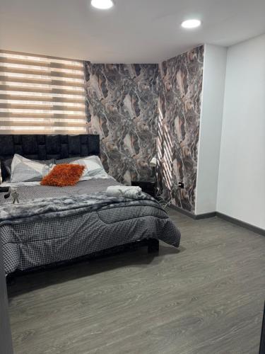 a bedroom with a bed in a room with a wall at Apartamento centro comercial in Ipiales