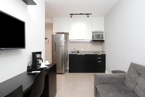 a living room with a couch and a kitchen at Espaço 26m Bela Vista in Sao Paulo