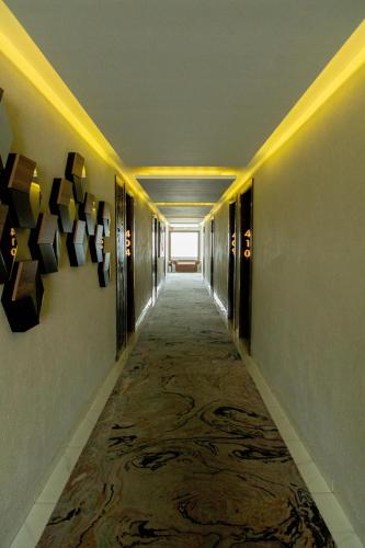 a long hallway with a carpeted floor in a building at Hotel Dali Plaza Ejecutivo in Guadalajara