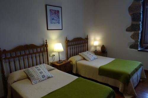 a bedroom with two beds and two lamps on tables at Días de Luna in Sena de Luna