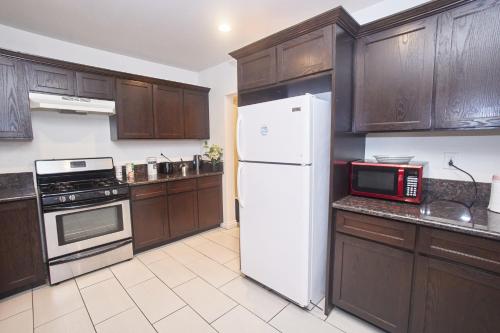 a kitchen with wooden cabinets and a white refrigerator at Blue Private Room near BMO Stadium USC and K-Town in Los Angeles