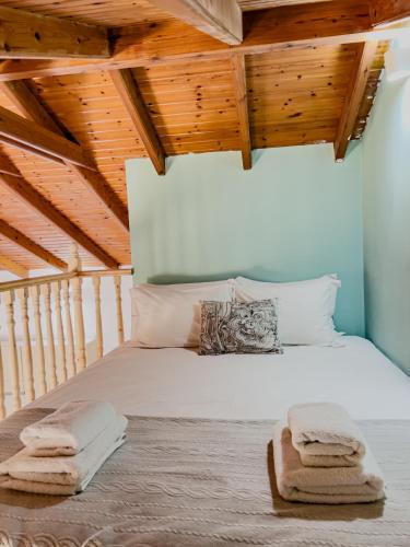 a bedroom with a large white bed with wooden ceilings at Live in Lemnos Studios in Moudhros