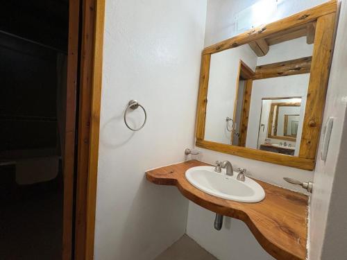 a bathroom with a sink and a mirror at Lodge Copahue Expeditions in Caviahue
