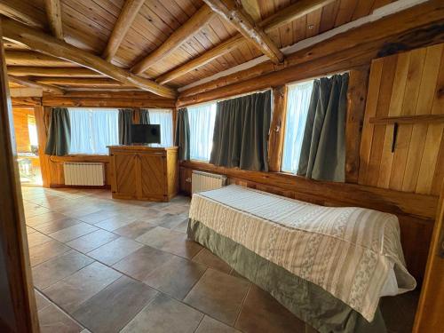 a bedroom with a bed in a wooden house at Lodge Copahue Expeditions in Caviahue