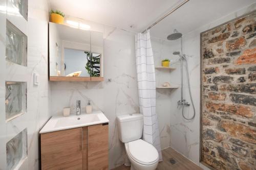 a white bathroom with a toilet and a sink at Eloúnda blue city center WiFi traditional for two in Elounda