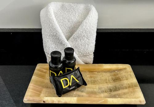 two bottles of alcohol on a wooden cutting board at Hotel Dali Plaza Ejecutivo in Guadalajara